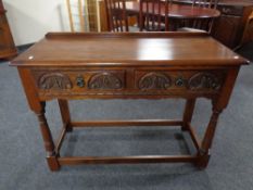 A carved oak Old Charm two drawer console table.