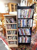 Two media storage units containing assorted DVDs and CDs.