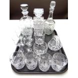 A tray of three cut glass decanters, set of four whisky tumblers,