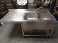 A stainless steel commercial two tier double sink unit with drainer