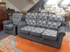 A contemporary three seater settee and armchair in two-tone grey fabric