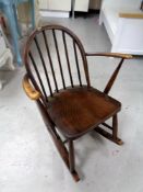 An Ercol solid elm and beech child's rocking chair in antique finish