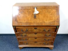 A burr walnut bureau fitted with four drawers