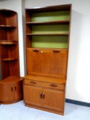 A mid century G-plan teak cocktail bookcase fitted with drawer and cupboards