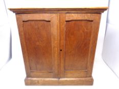 An Edwardian oak two-door collector's cabinet fitted with five drawers internally