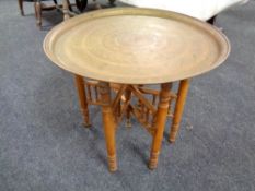 A circular Eastern folding brass topped table