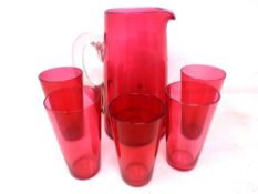 A cranberry glass jug and five beakers