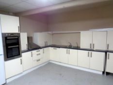 A cream high gloss fifteen cupboard, three drawer fitted kitchen with counter tops,