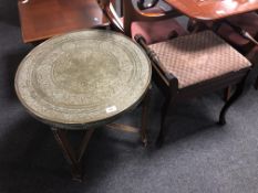 A circular Eastern folding brass topped table together with an Edwardian piano stool
