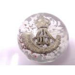 A glass paperweight with inset Durham Light Infantry cap badge