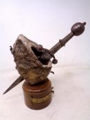 A medieval style dagger on stone and wooden base