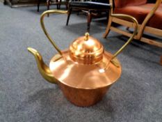 An oversized copper and brass kettle