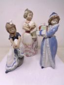 Three Nao figures of a girl with presents,
