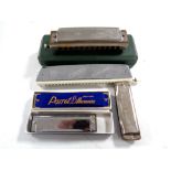 A group of five harmonicas including Hohner, Tower,