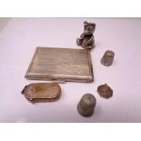 A silver card case, two silver thimbles,