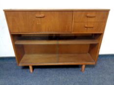 A mid century teak sliding glass door bookcase fitted with two drawers and bureau