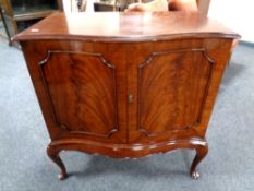 A Victorian style mahogany bow fronted double door cabinet on raised legs