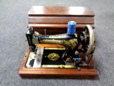 A Singer hand sewing machine in wooden case