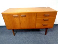 A 20th century teak Uniflex double door sideboard fitted with three drawers