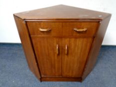 A 20th century teak double door low corner cabinet fitted a drawer