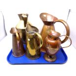 A tray of five brass and copper jugs