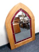 A pine arch topped framed stained leaded glass mirror