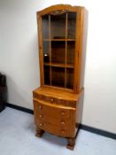 A 1930's carved oak glazed bookcase fitted with four drawers