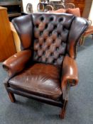 A Chesterfield buttoned and studded brown leather armchair