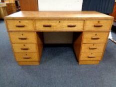 An early 20th century oak twin pedestal desk fitted with nine drawers