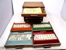 A mahogany and maple miniature five drawer chest containing mahjong counters and rule book