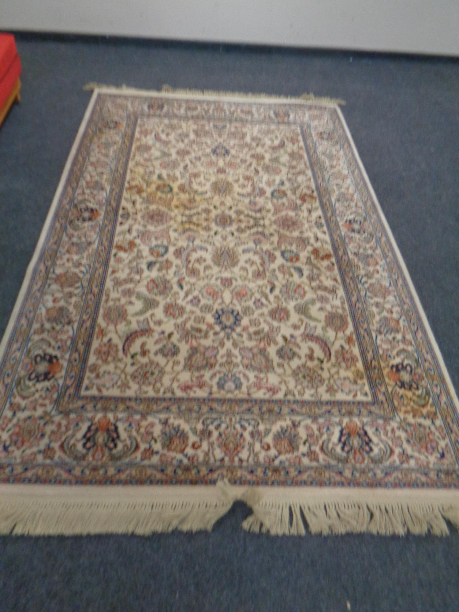 A Persian design fringed carpet.