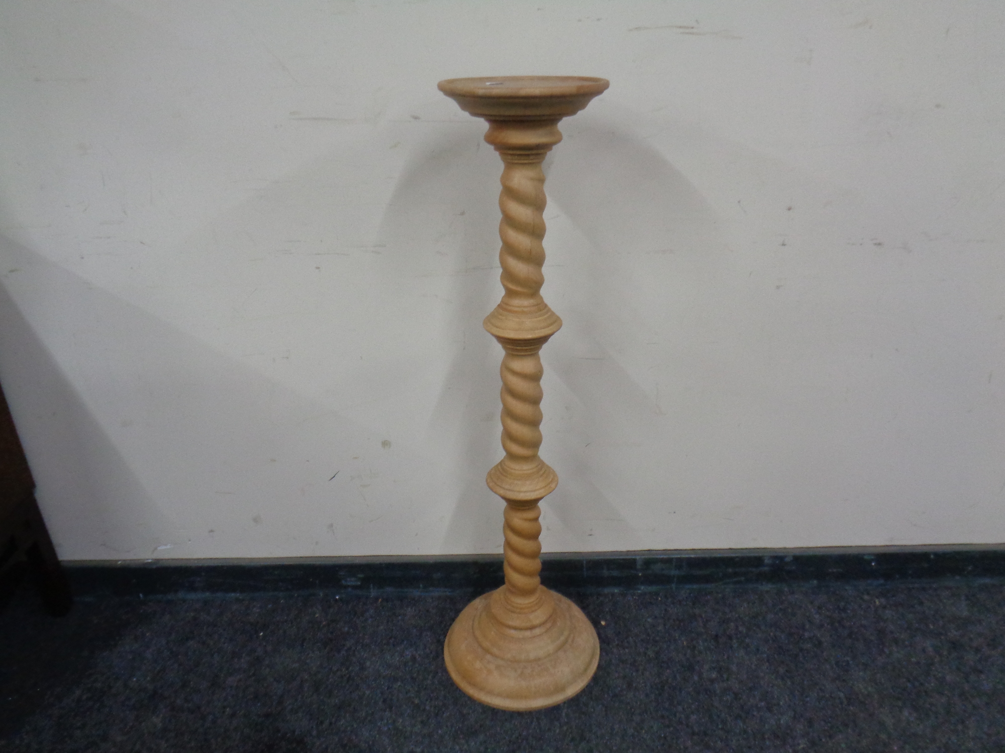 A pine pedestal plant stand.