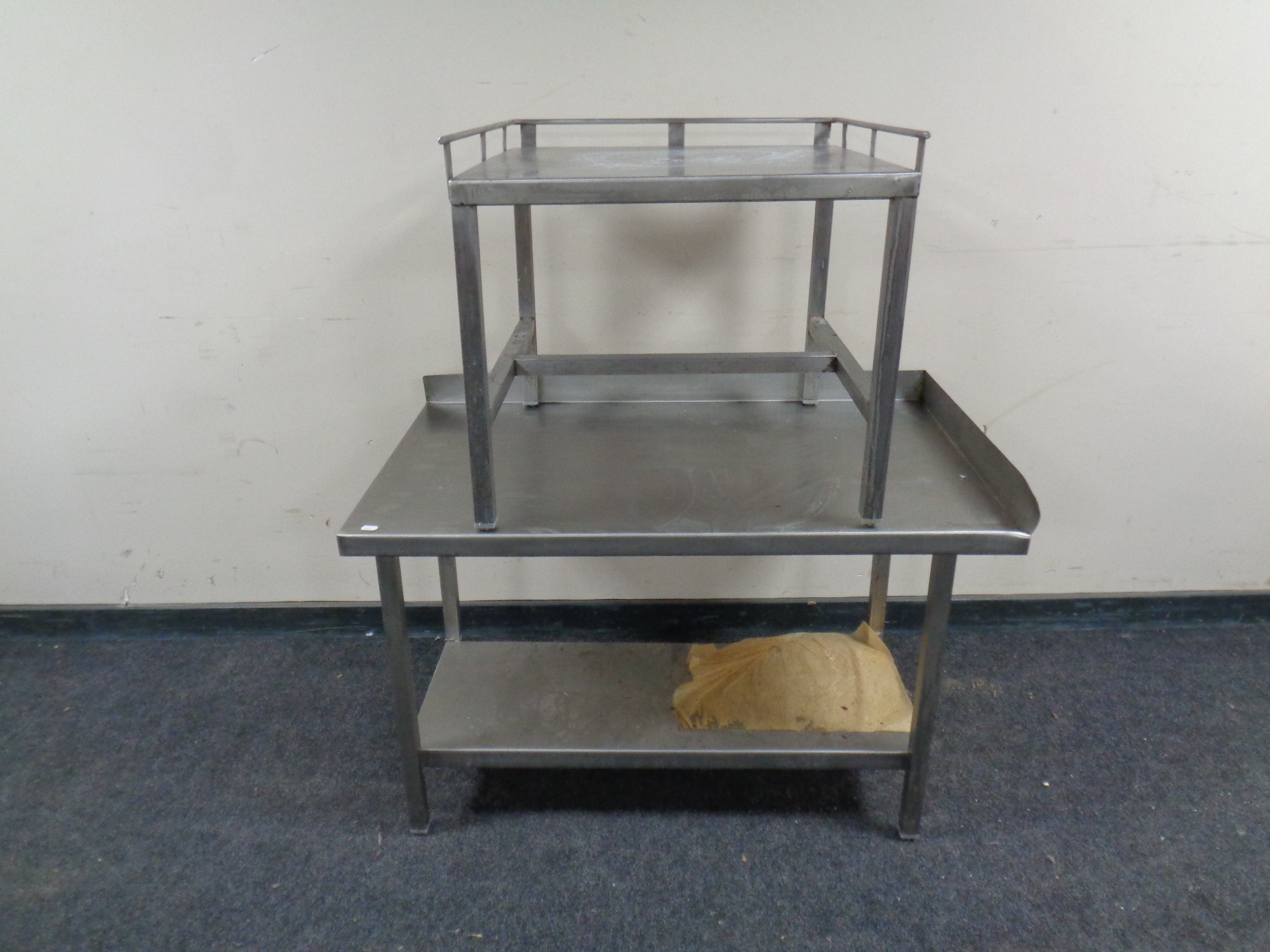 A two-tier stainless steel preparation table together with a further small low table.