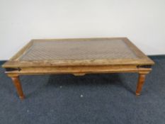 A Mexican style low coffee table with glass top.