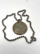 A silver coin pendant on silver rope chain