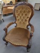 A Victorian mahogany open armchair in a brown buttoned dralon