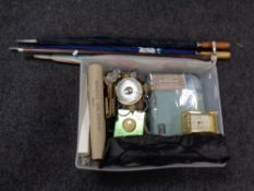 A box containing three umbrellas, a walking stick with pickaxe head handle, barometer,