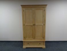 A contemporary light oak wardrobe fitted with a drawer.