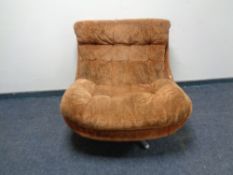 A late twentieth-century swivel armchair upholstered in brown fabric.