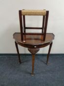 An early twentieth century walnut D-shaped table together with a foot stool.