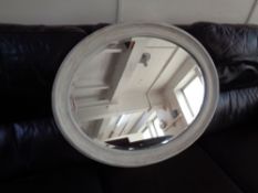 An oval painted beveled mirror.
