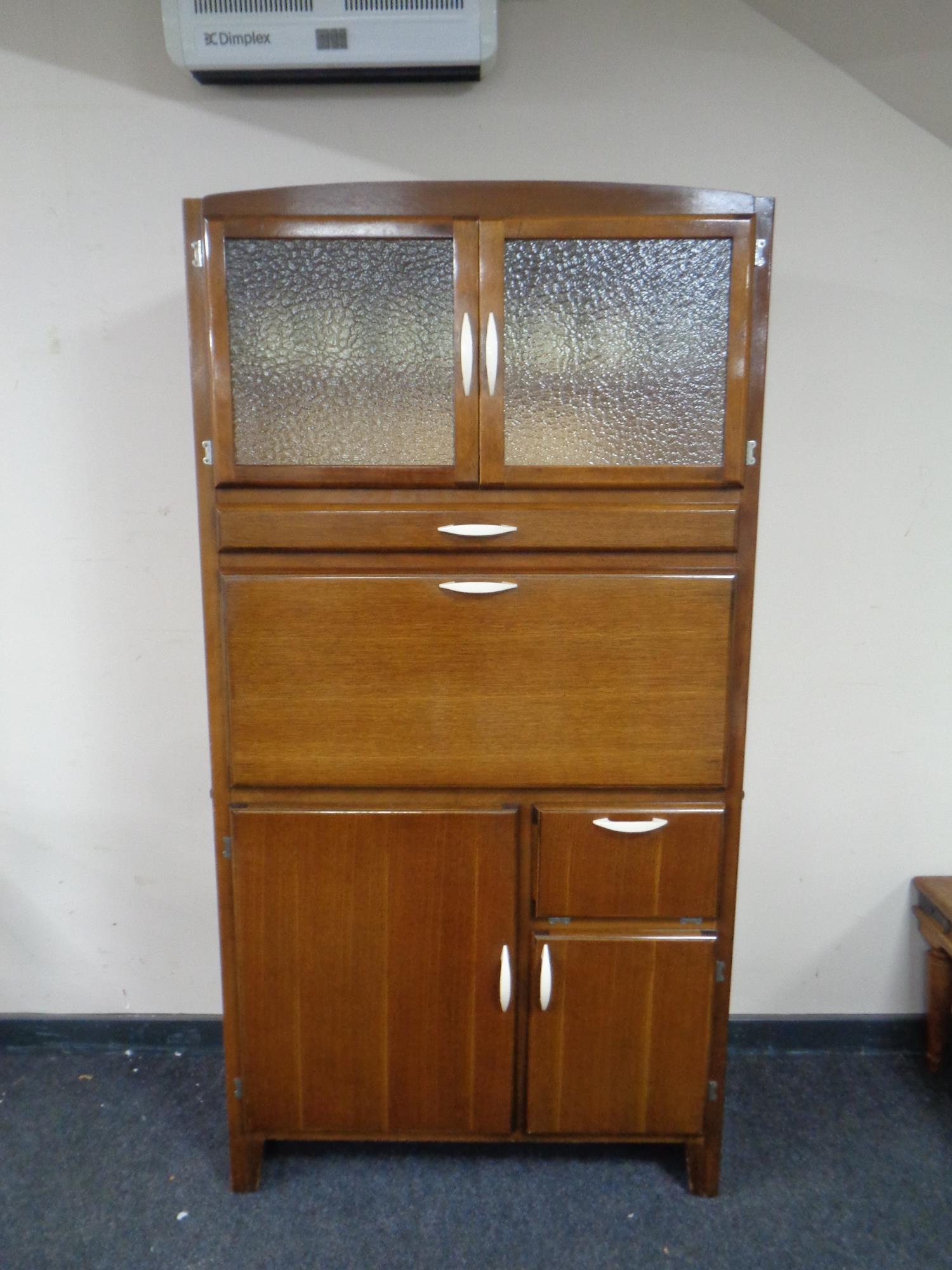 A mid-century kitchen cabinet with fitted interior.