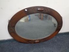 An Edwardian oak oval mirror