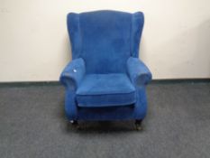 A Parker Knoll blue upholstered wing armchair.
