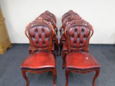 A set of six carved dining room chairs upholstered in Burgundy leather.