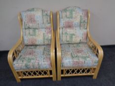 A pair of cane conservatory armchairs.