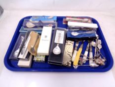 A tray containing a large quantity of souvenir tea spoons, various antique and later cutlery.