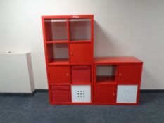 A two section red storage cabinet fitted with drawers.