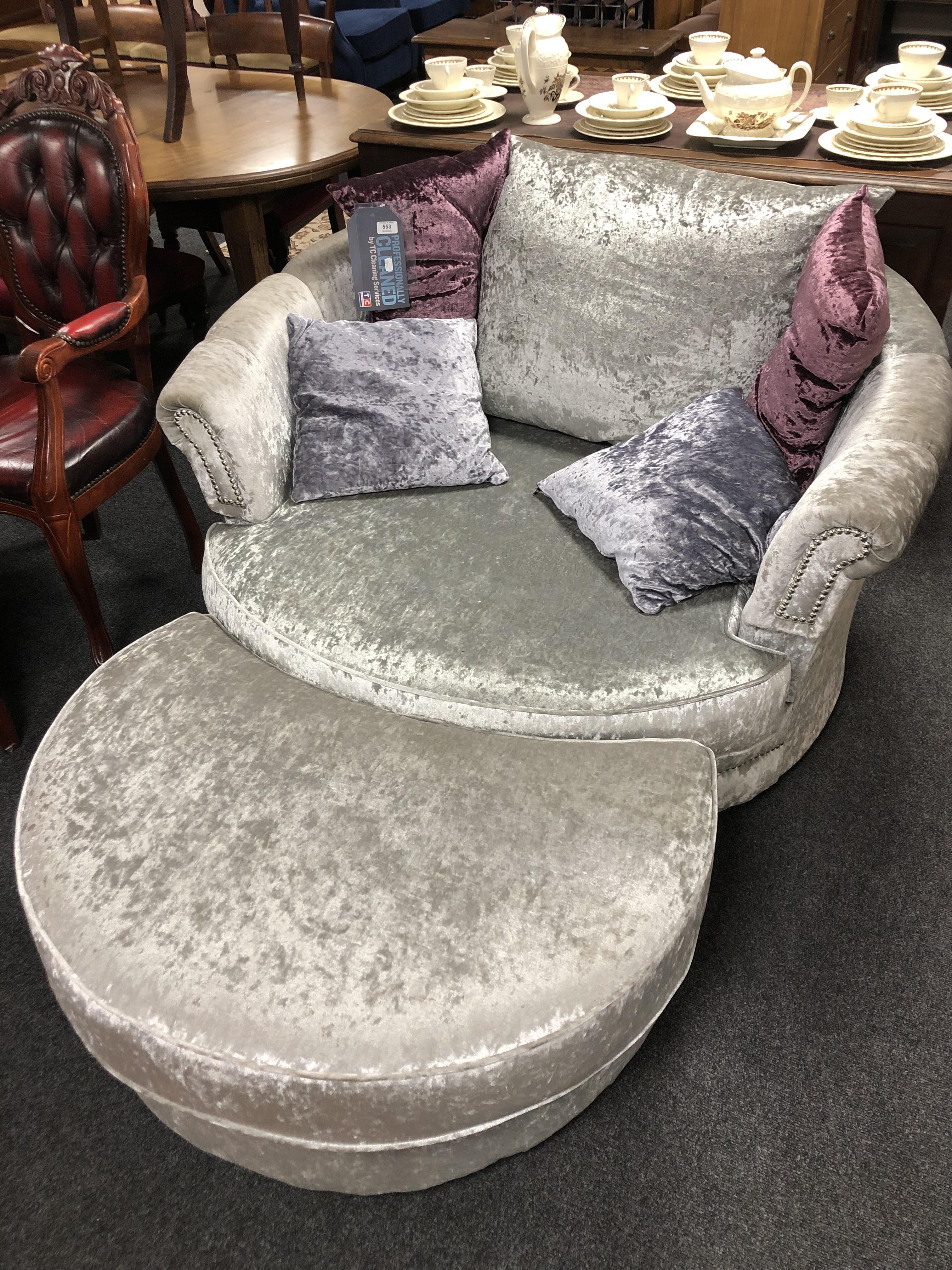 A contemporary swivel cuddle chair with foot stool.