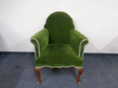 A green upholstered Georgian style armchair.